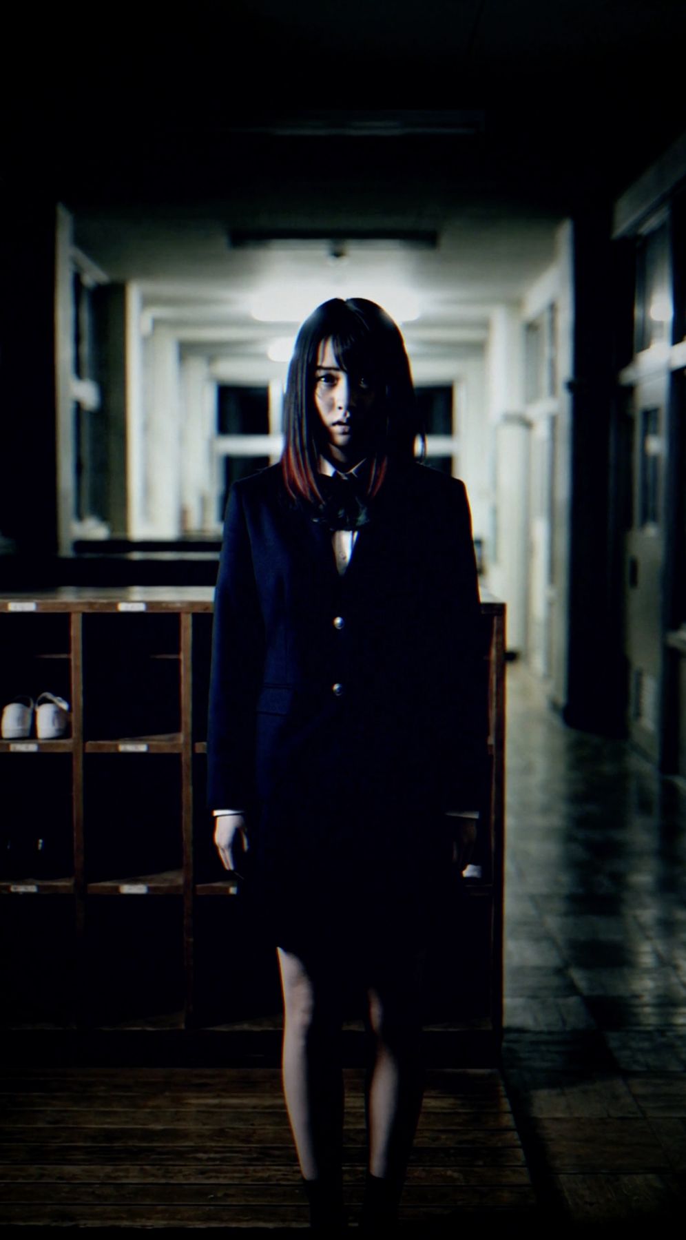 暗い廊下に立つ制服の女性
