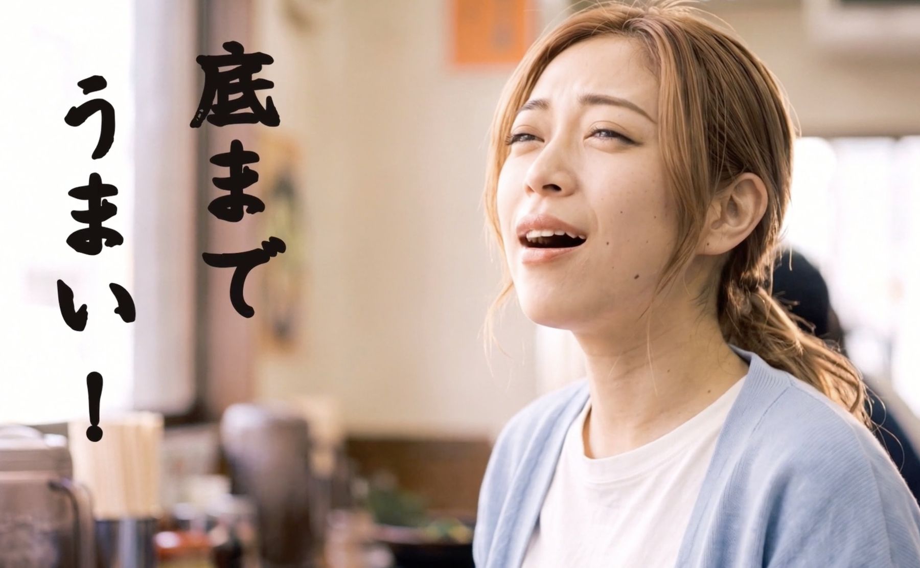 スープを飲んで「底までうまい」と笑う女性